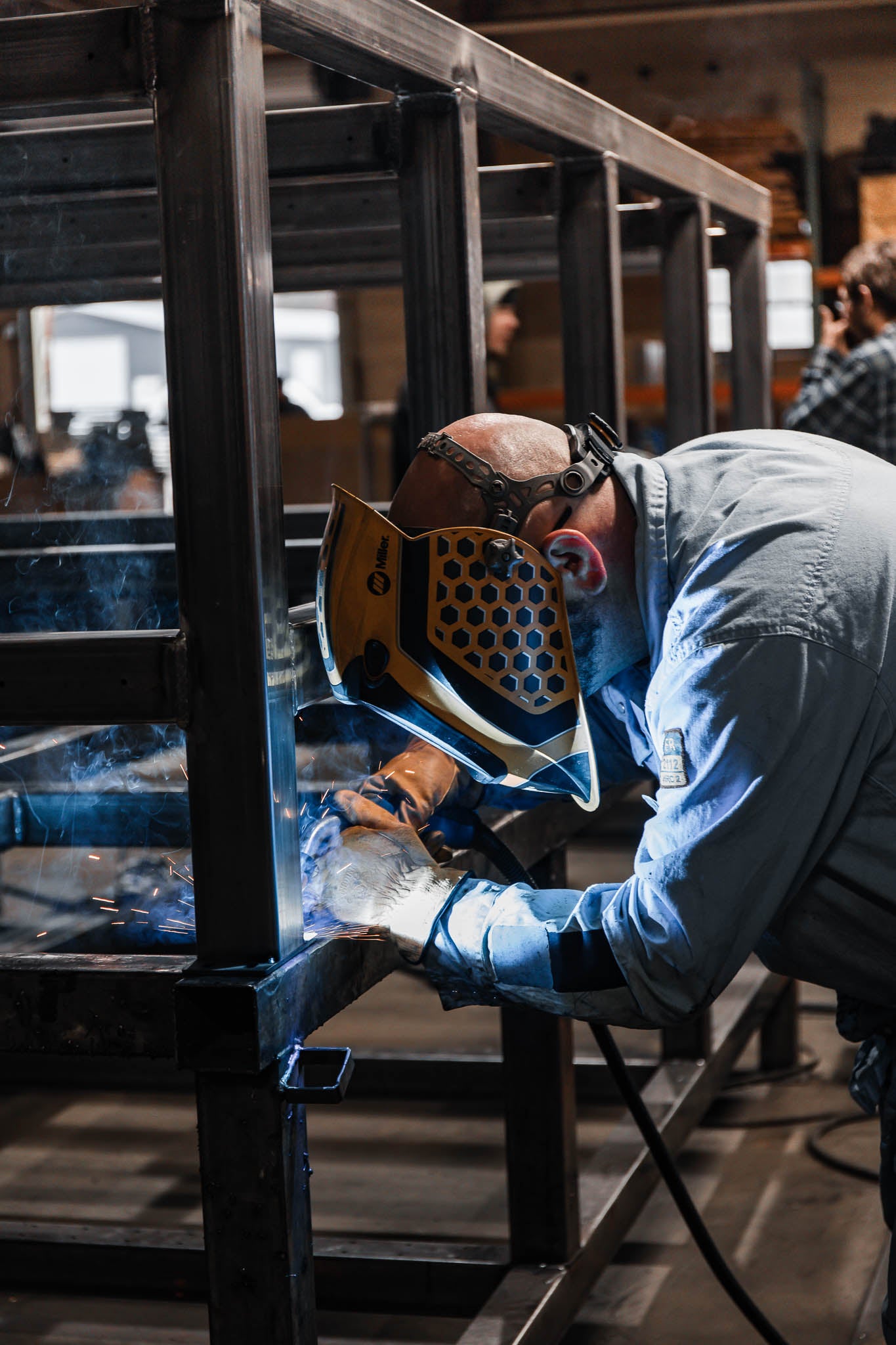 Person welding metal in a workshop setting