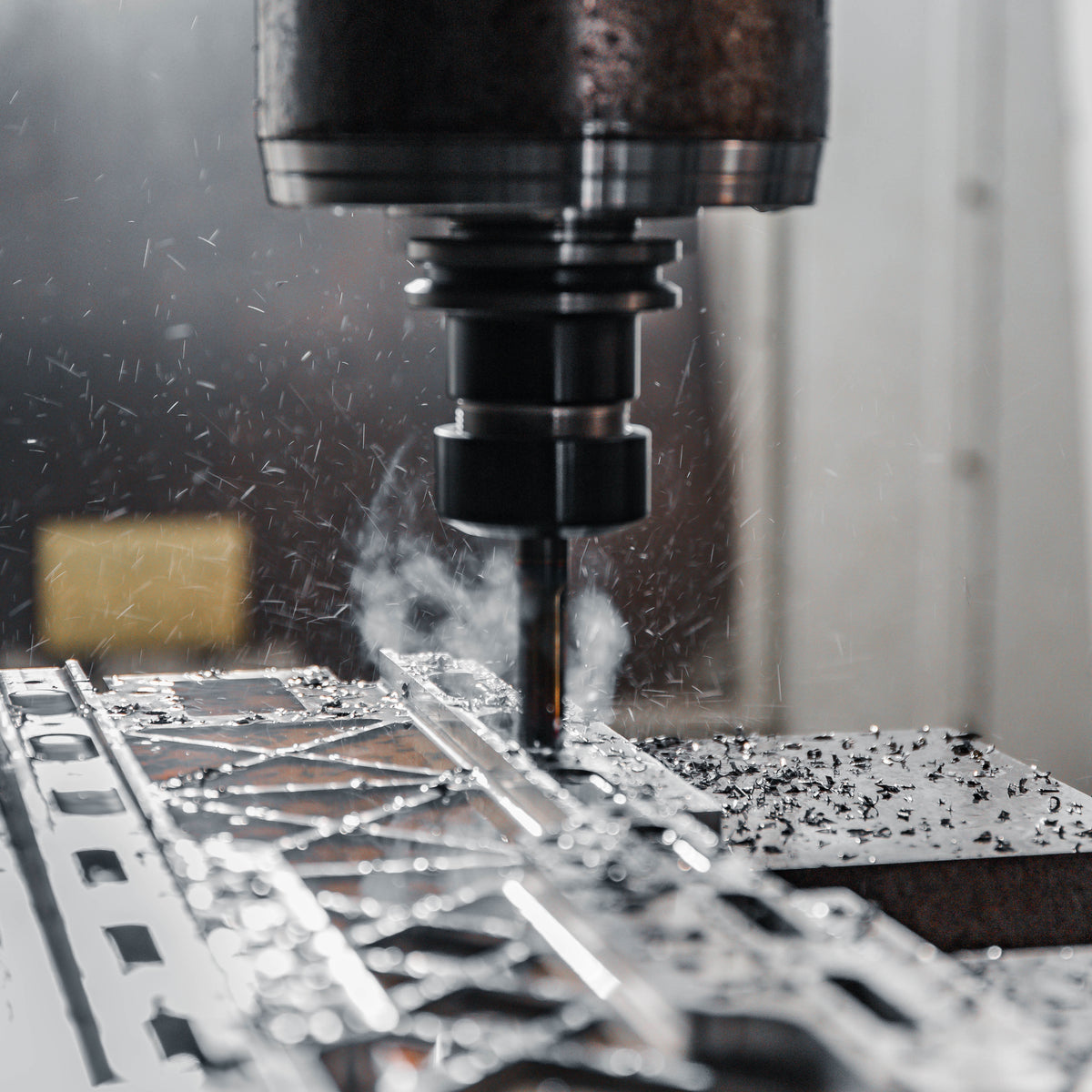 CNC milling machine cutting metal with metal shavings flying