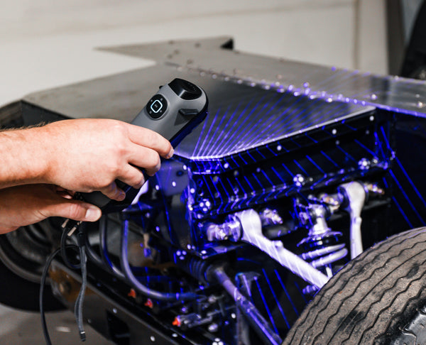 Person 3d scanning a car engine with a 3d scanning device