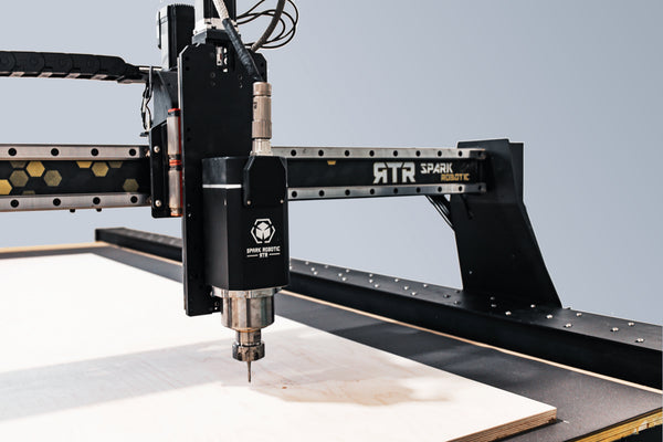 CNC Router machine in action on a wooden surface with a light gray background