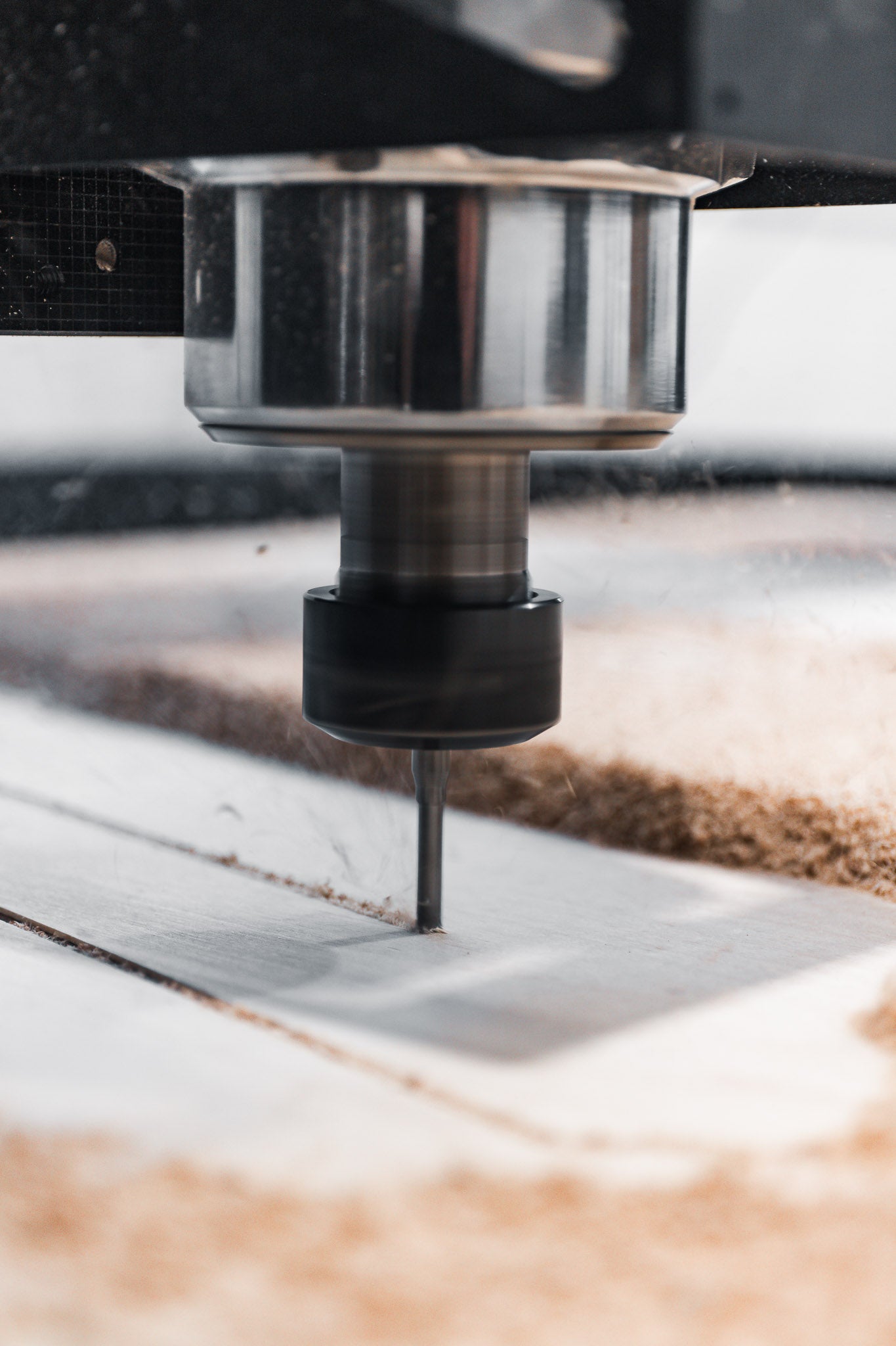 CNC router machine tool cutting through material with a focus on the tool and workpiece.