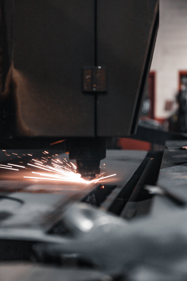 CNC machine cutting metal with sparks in a workshop setting