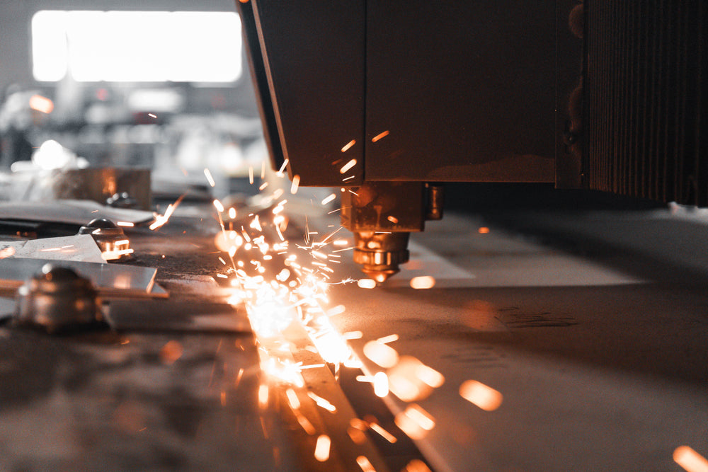 Laser cutting machine in action with sparks on a metal surface