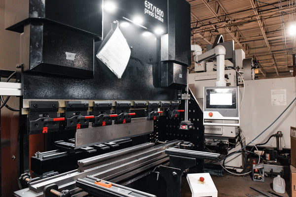 Large industrial press brake machine in a workshop setting