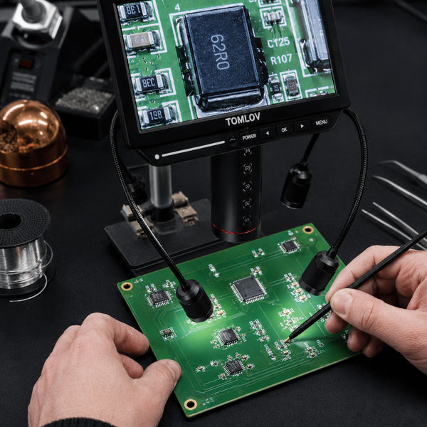 Person working on a circuit board with a magnifying device 