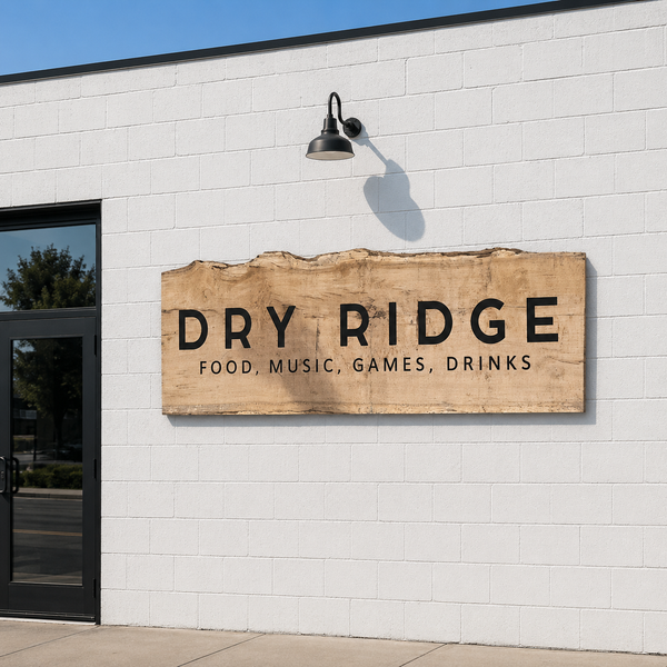 Wooden sign with 'Dry Ridge' on a white brick building