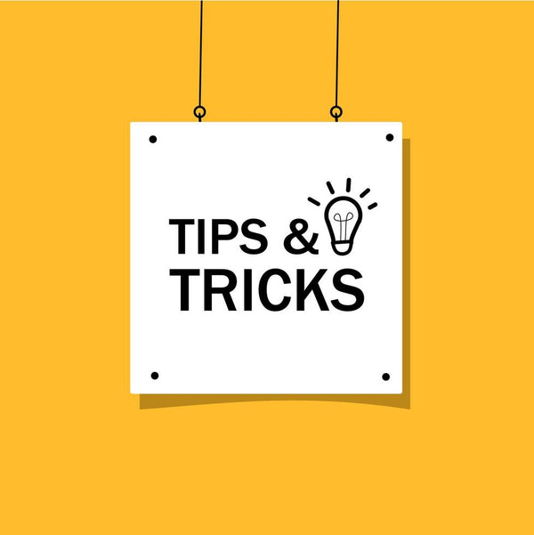 White sign with 'Tips & Tricks' text and light bulb icon on a yellow background