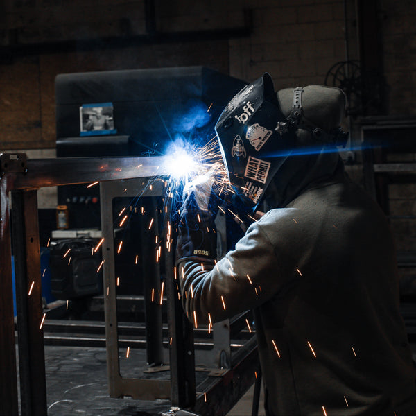Person welding in a workshop with sparks flying
